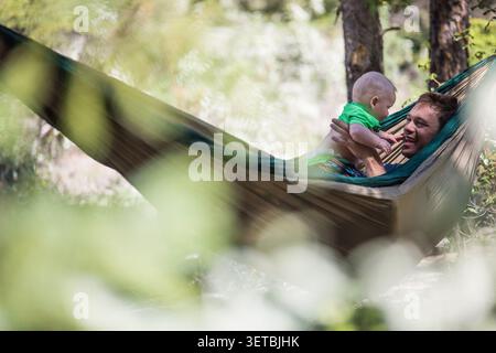 Father and baby son relaxing in a hammock outdoors Stock Photo