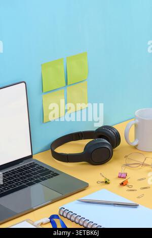 Creative workspace concept with headphones laptop and sticky notes on desk Stock Photo