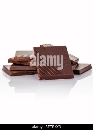 Pieces of dark chocolate stacked on a white background Stock Photo