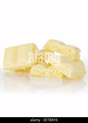 Pile of broken bubbly white chocolate pieces Stock Photo