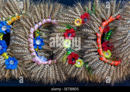 Ukrainian traditional wreaths from ears of wheat and flowers on a street market for sale to tourists in Kyiv, Ukraine. Close up Stock Photo