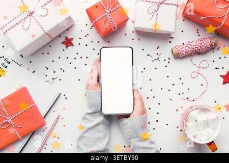 Modern cellphone with white blank screen in woman hands Stock Photo
