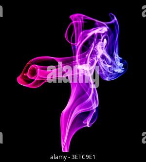 Red, blue and purple smoke dances with effortless freedom, swirling through the darkness like a fleeting work of living art. Stock Photo