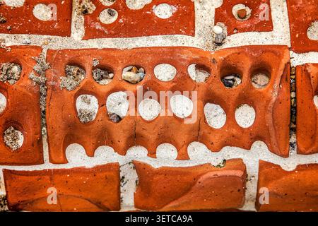 Sea weathered bricks reveal the relentless power of seawater erosion creating a colourful textured backdrop Stock Photo