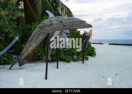 Driftwood dolphin sculptures on white sand beach in the Maldives Stock Photo