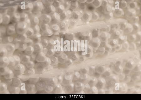 Granular white foam, porous foam consists of many dense layers of synthetic foam for thermal insulation in construction. Stock Photo