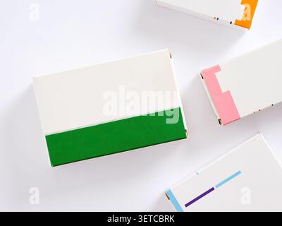 Colorful medicine boxes lying on white background representing pharmaceutical industry and medicine concept. Mockup with empty labels. Stock Photo