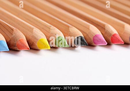 Colorful pencils arranged in a row on a white background, ready for artistic creation Stock Photo