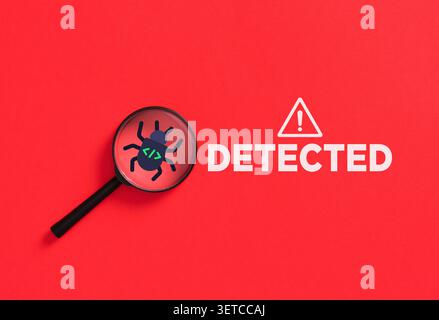 Magnifying glass highlighting a program software bug icon with code syntax on a red background with a detected warning message Stock Photo