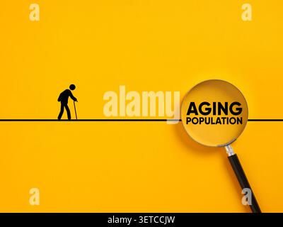 Senior person walking on a line with Aging population text inside a magnifying glass, representing demographic changes and aging society Stock Photo