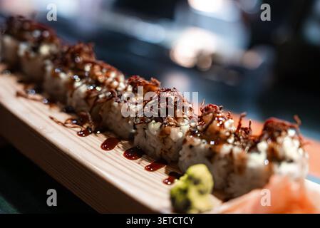 Sushi rolls on wooden platter with sauce in Maldives resort dining Stock Photo