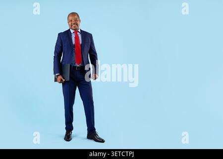 Confident mature African American businessman in navy suit holding folder Stock Photo