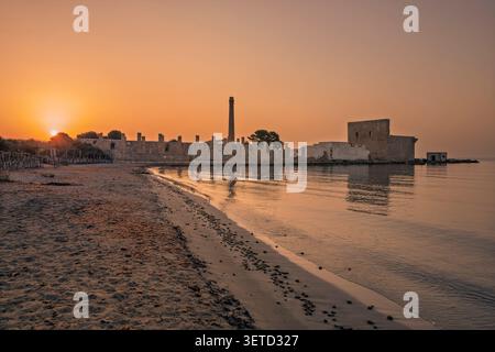 Dawn light on the ruins of the old factory for the processing of tuna and of the medieval watch tower at Vendicari, Syracuse, Sicily, Italy. Stock Photo