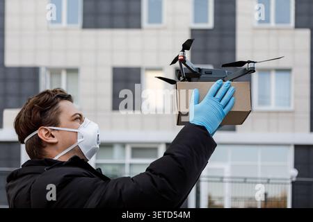 Man in protective mask and gloves receiving quadrocopter Stock Photo