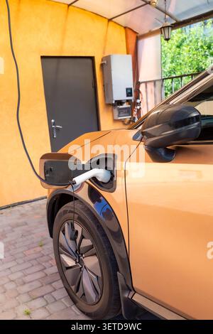 Close up of electric vehicle charging in driveway . Stock Photo