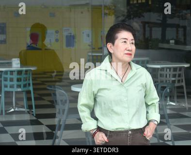 elder woman strong and healthy posing and smiling in community mall garden Stock Photo