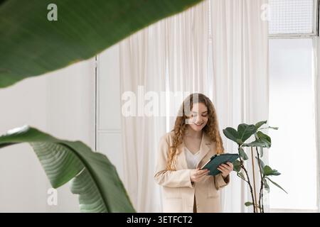 Young woman smiling using digital tablet indoors Stock Photo