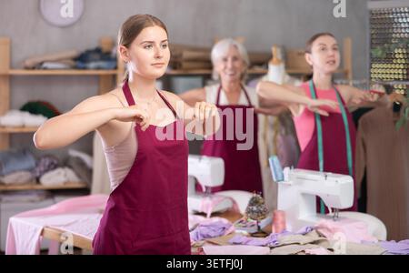 team of dressmakers doing a warm-up in the workshop Stock Photo