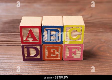 Cubes with letters on wooden table, closeup Stock Photo