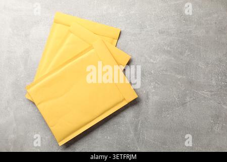 Stack of yellow envelopes on grey table, top view. Space for text Stock Photo