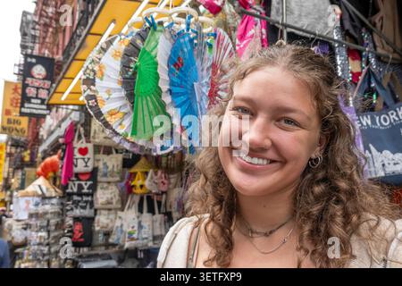 Pretty teenage female tourist, smiling on the streets of Chinatown, 2026, New York City, USA Stock Photo