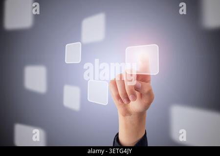 Hand touching virtual interface with transparent digital buttons, futuristic technology and business innovation concept Stock Photo