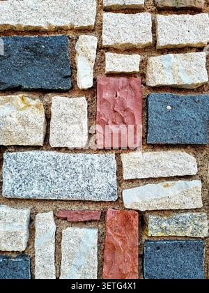 Close-up of the colorful texture of wall cladding made of stones of various shapes and colors Stock Photo