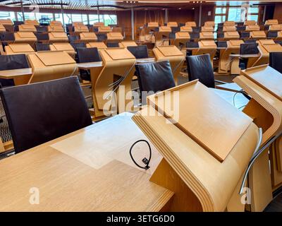 Empty legislative debating chamber with wooden desks and leather chairs at the Scottish Parliament Building, Holyrood, Scotland. Stock Photo