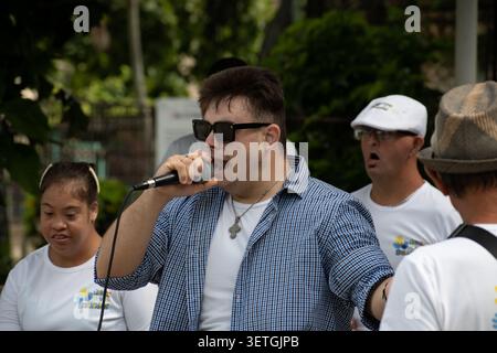 Young Cuban man with Down syndrome singing into a microphone during a unique social project performance in Ciego de Avila, Cuba Stock Photo