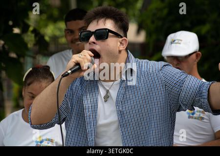Young Cuban man with Down syndrome singing into a microphone during a unique social project performance in Ciego de Avila, Cuba Stock Photo