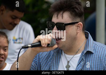 Young Cuban man with Down syndrome singing into a microphone during a unique social project performance in Ciego de Avila, Cuba Stock Photo