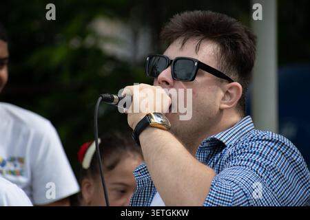 Young Cuban man with Down syndrome singing into a microphone during a unique social project performance in Ciego de Avila, Cuba Stock Photo