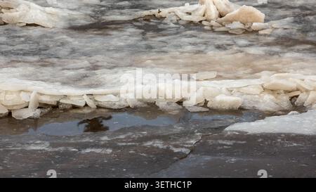 Broken river ice sheets floating on melting water surface during early spring thaw Stock Photo