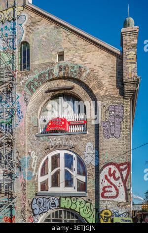 Copenhagen - Denmark - 11-15-2025: Den Gra Hal Brick Facade with Graffiti in Freetown Christiania, Street Art Culture Stock Photo