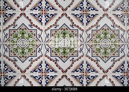 Traditional hand-painted ceramic tiles featuring intricate geometric floral patterns displayed on a bright wall, capturing a timeless Mediterranean ae Stock Photo