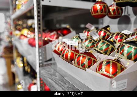 Many colorful bright festive Christmas handmade baubles toys decoration sale in boxes at factory manufacture store. Multicolored hand painted New year Stock Photo