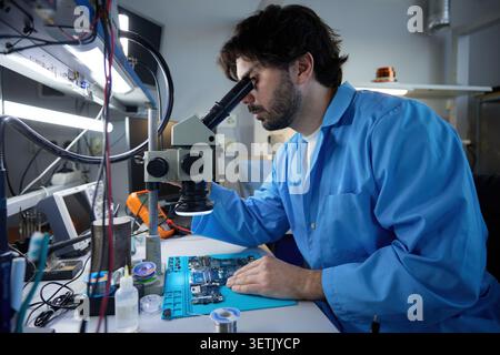 A technician repairing circuit board under microscope Stock Photo