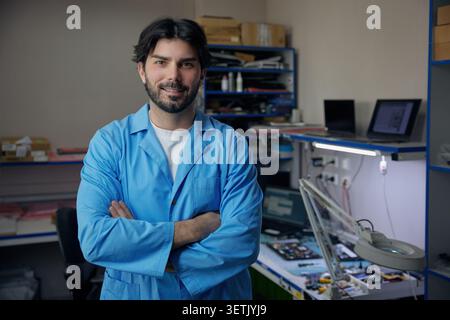 A man wearing a lab coat stands confidently with his arms crossed Stock Photo