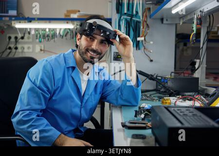 Portrait of a man soldering technician, wearing a pair of protective goggles in a lab Stock Photo