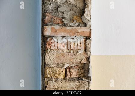 This captures the raw detail of an exposed brick wall and crumbling plaster during the demolition phase of a historic Wilhelminian era apartment build Stock Photo