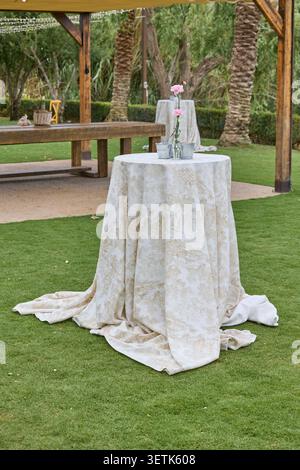 Elegant cocktail table with flowers prepared for outdoor wedding reception. Stock Photo