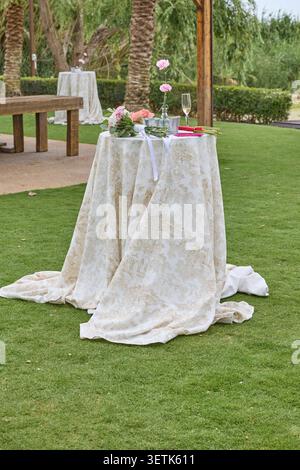 Elegant cocktail table with flowers prepared for outdoor wedding reception. Stock Photo