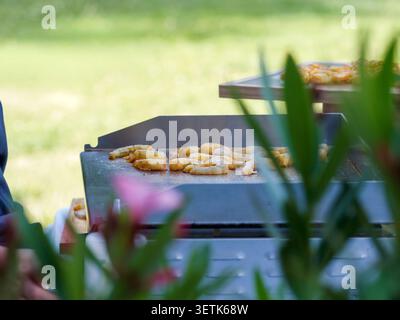 Freshly grilled shrimp served as gourmet appetizers during a catered cocktail reception in France, with chefs preparing and serving the seafood live. Stock Photo
