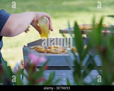 Freshly grilled shrimp served as gourmet appetizers during a catered cocktail reception in France, with chefs preparing and serving the seafood live. Stock Photo