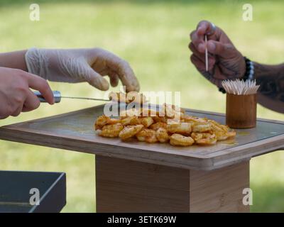 Freshly grilled shrimp served as gourmet appetizers during a catered cocktail reception in France, with chefs preparing and serving the seafood live. Stock Photo