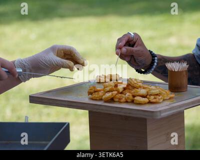 Freshly grilled shrimp served as gourmet appetizers during a catered cocktail reception in France, with chefs preparing and serving the seafood live. Stock Photo