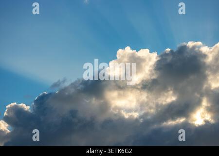 Sun rays breaking through clouds in blue sky over Punta Cana resort Stock Photo