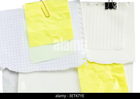 Scattered torn paper sheets collage with binder clip and sticky notes isolated. Stock Photo