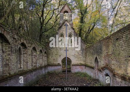 Stone and brick ruins of abandoned 19th-century St Mary's Church, roofless and forgotten, deeply hidden in the overgrown autumn woodlands of Bedham. Stock Photo