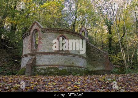 Stone and brick ruins of abandoned 19th-century St Mary's Church, roofless and forgotten, deeply hidden in the overgrown autumn woodlands of Bedham. Stock Photo
